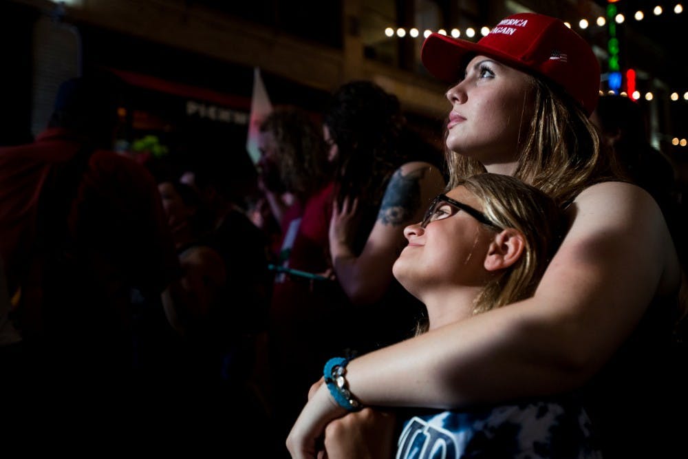 Cleveland, Ohio residents Emma Melito, 9, and Marisa Melita, 17, watch republican presidential nominee Donald Trump give a speech on July 21, 2016, the fourth day of the Republican National Convention, in Cleveland, Ohio. 