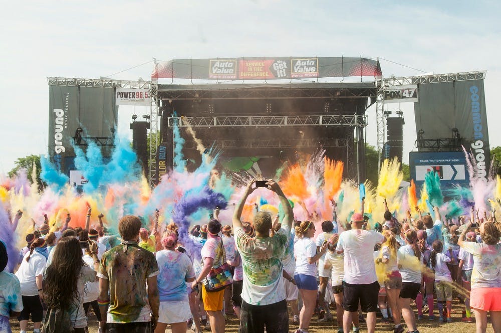 <p>Participants throw color in the air at the end of The Color Run on July 12, 2014, at Adado Riverfront Park in downtown Lansing. "The Happiest 5K on the Planet" had participants of all ages. Danyelle Morrow/The State News</p>