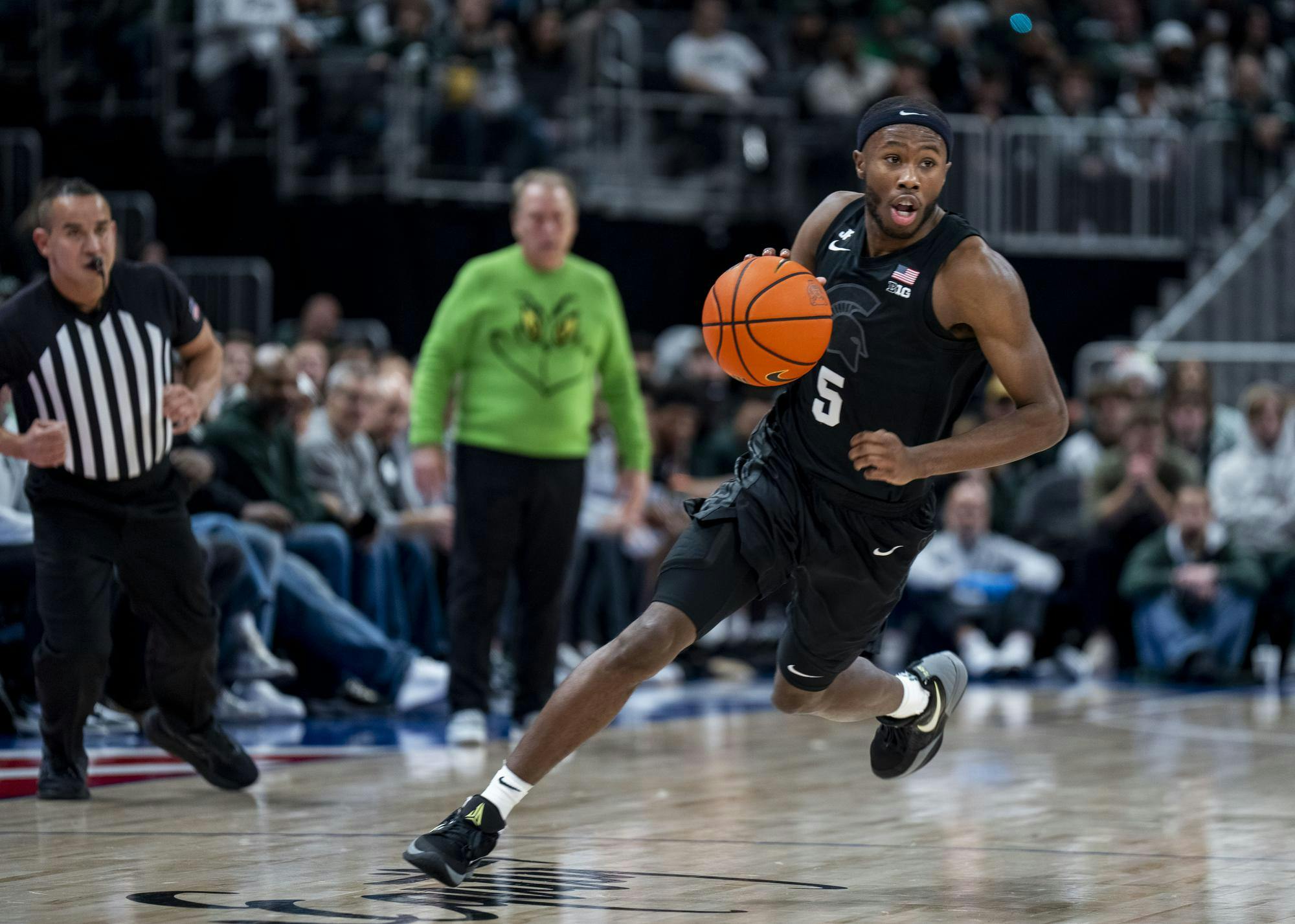 Michigan State junior guard Tre Holloman (5) takes control of the ball at the Little Caesars Arena on Dec. 17, 2024. The Spartans defeated the Golden Grizzlies 77-58. 