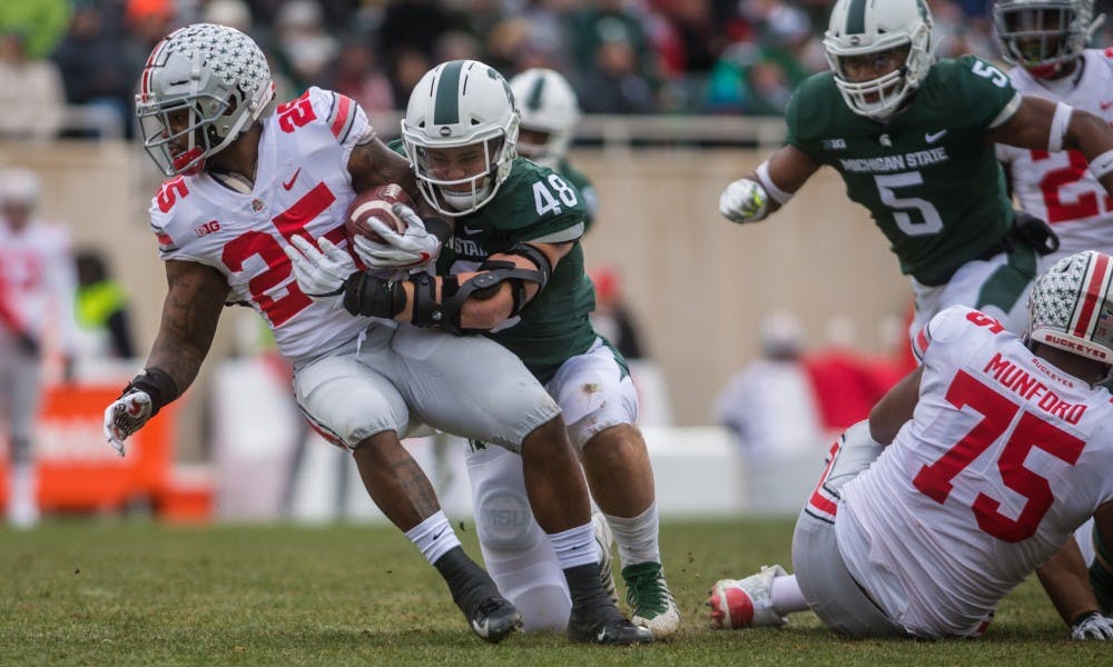 Junior defensive end Kenny Willekes (48) tackles Ohio State running back Mike Weber (25) during the game against Ohio State at Spartan Stadium on Nov. 10, 2018. The Spartans trail the Buckeyes 7-3 at halftime.