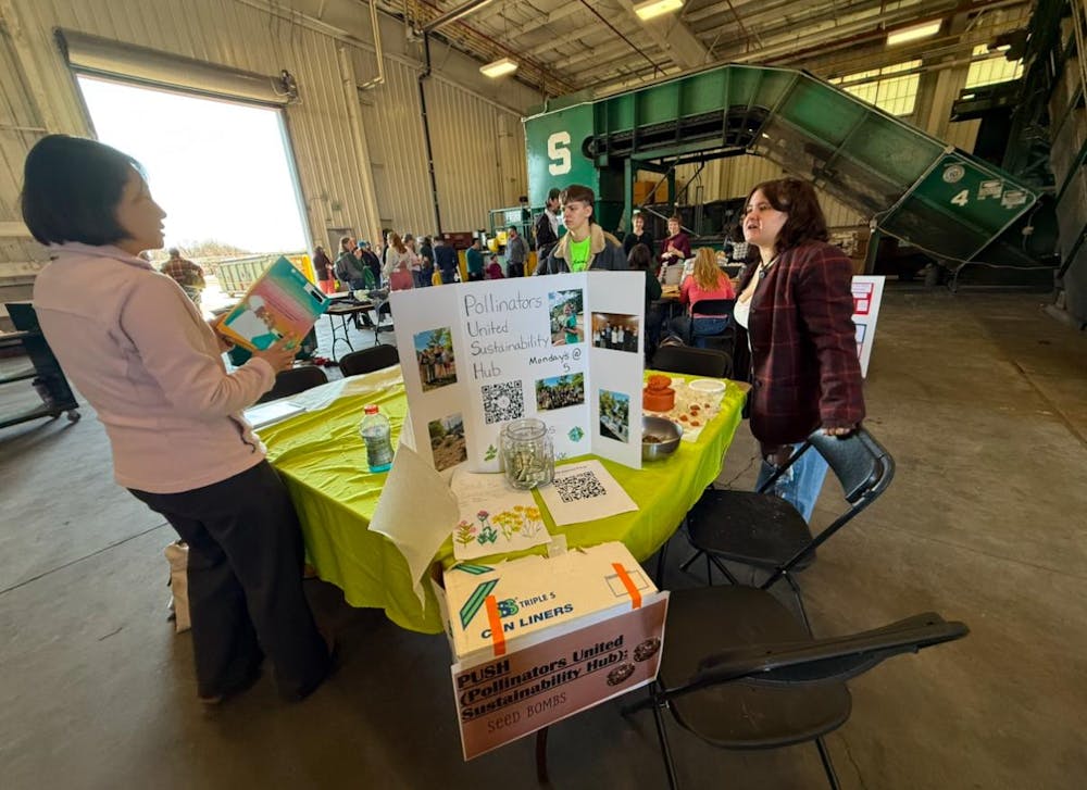 Attendees at look at the various tables and activities at the MSU Earth Bash at the Surplus Store on April 12, 2025