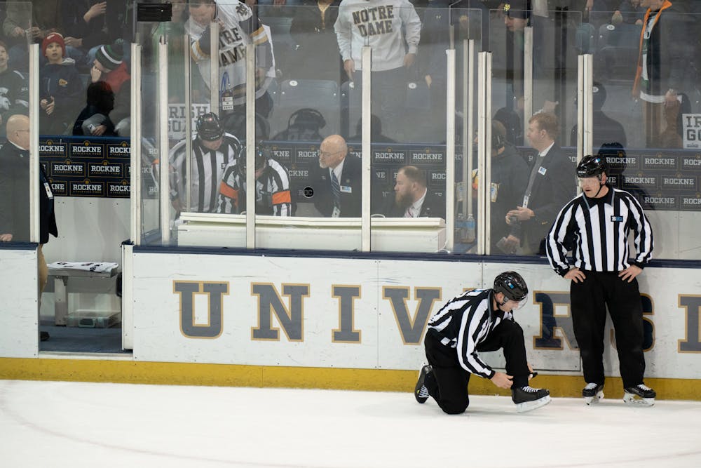 <p>Two referees share a few words while a Notre Dame goal is reviewed in the booth behind them at Compton Family Ice Arena in Notre Dame, IN on Friday, March 4, 2023. MSU’s challenge failed and the goal stood.</p>