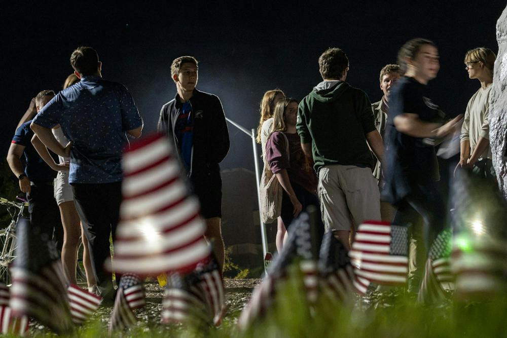 Members of MSU Young Americans for Freedom and MSU College Republicans gather around the Rock while preparing a 9/11 memorial at Michigan State University in East Lansing, Mich., Thursday, Sept. 10, 2026. The organizations placed 2,977 American flags around the Rock, one for each victim killed in the Sept. 11, 2001, terrorist attacks, to mark the 25th anniversary of the attacks.
