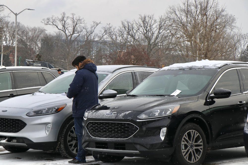 <p>MSU parking enforcement checking a Ford outside of Erickson Hall on Jan. 18, 2023. "The silver car has eight unpaid parking tickets, so we are going to have to tow it," said the MSU parking enforcement.</p>