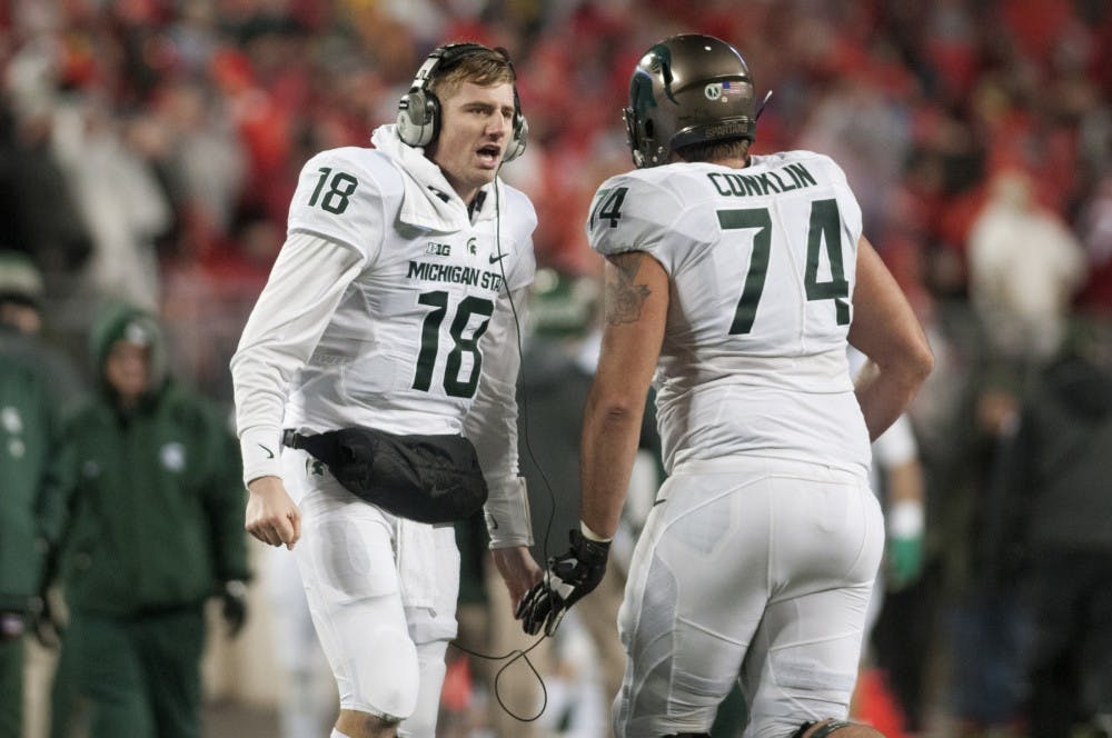<p>Senior quarterback Connor Cook low fives junior offensive tackle Jack Conklin during the game against Ohio State on Nov. 21, 2015 at Ohio Stadium in Columbus, Ohio. The Spartans defeated the Buckeyes, 17-14.</p>