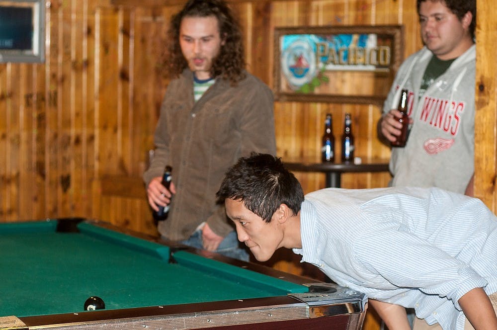 <p>Chemistry senior Joel Stewart plays pool Jan. 23, 2015, during the reopening of The Landshark Raw Bar and Grill, 101 E Grand River Ave. in East Lansing. Kennedy Thatch/The State News</p>