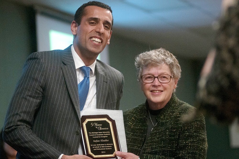 <p>Graduate student and COGS president Stefan Fletcher poses for COGS office manager Rebecca Mizell with MSU president Lou Anna K Simon on March 12, 2014, at International Center. Fletcher is stepping down from being president after serving for 5 years. Betsy Agosta/The State News</p>