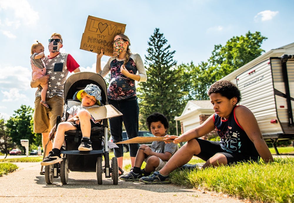 The Ferrin family and Solis kids stand and sit through an eight minute and 46 second moment of silence in honor of George Floyd. Protestors marched through the Pinecrest neighborhood on Juneteenth in solidarity with the Black Lives Matter movement in East Lansing June 19, 2020.