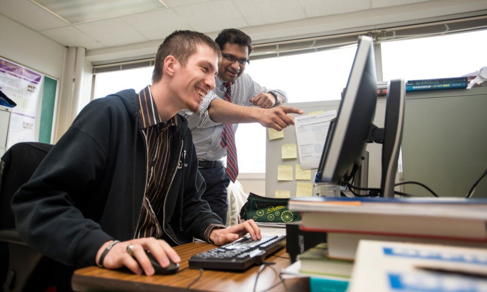 Associate professor of computer science and director of the i-PRoBe Lab Arun Ross gives feedback to doctoral student Steven Hoffman on March 18, 2016 at the Engineering Building. Ross conducts research on biometrics, which is the automatic recognition of individuals based on their biological traits such as fingerprints, faces, irises, and gaits.