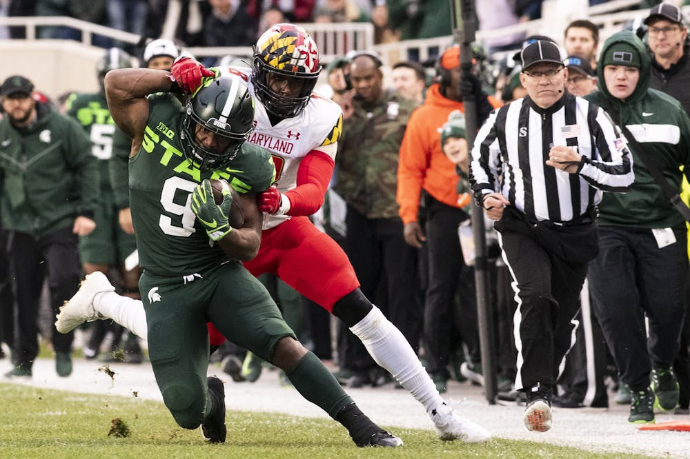 <p>Junior running back Kenneth Walker III (9) gets grabbed while running the ball during the game against Maryland on Nov. 13, 2021, at the Spartan Stadium.</p>