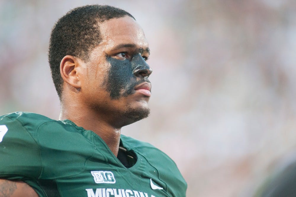 Junior defensive end William Gholston looks at the flag during the national anthem before the first home game of the season against Boise State on Friday night, Aug. 31, 2012, at Spartan Stadium. The game started at 8:06 p.m. and finished at 11:18 p.m. with Spartans winning 17-13. Natalie Kolb/The State News