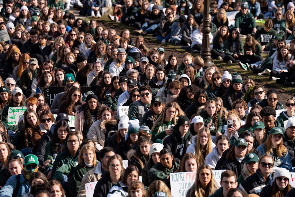 MSU students sit and listen to speakers at the Michigan State Capitol on Feb. 20, 2023, during a sit-down protest against gun violence held by Michigan State University students, one week after a mass shooting took place on their campus.