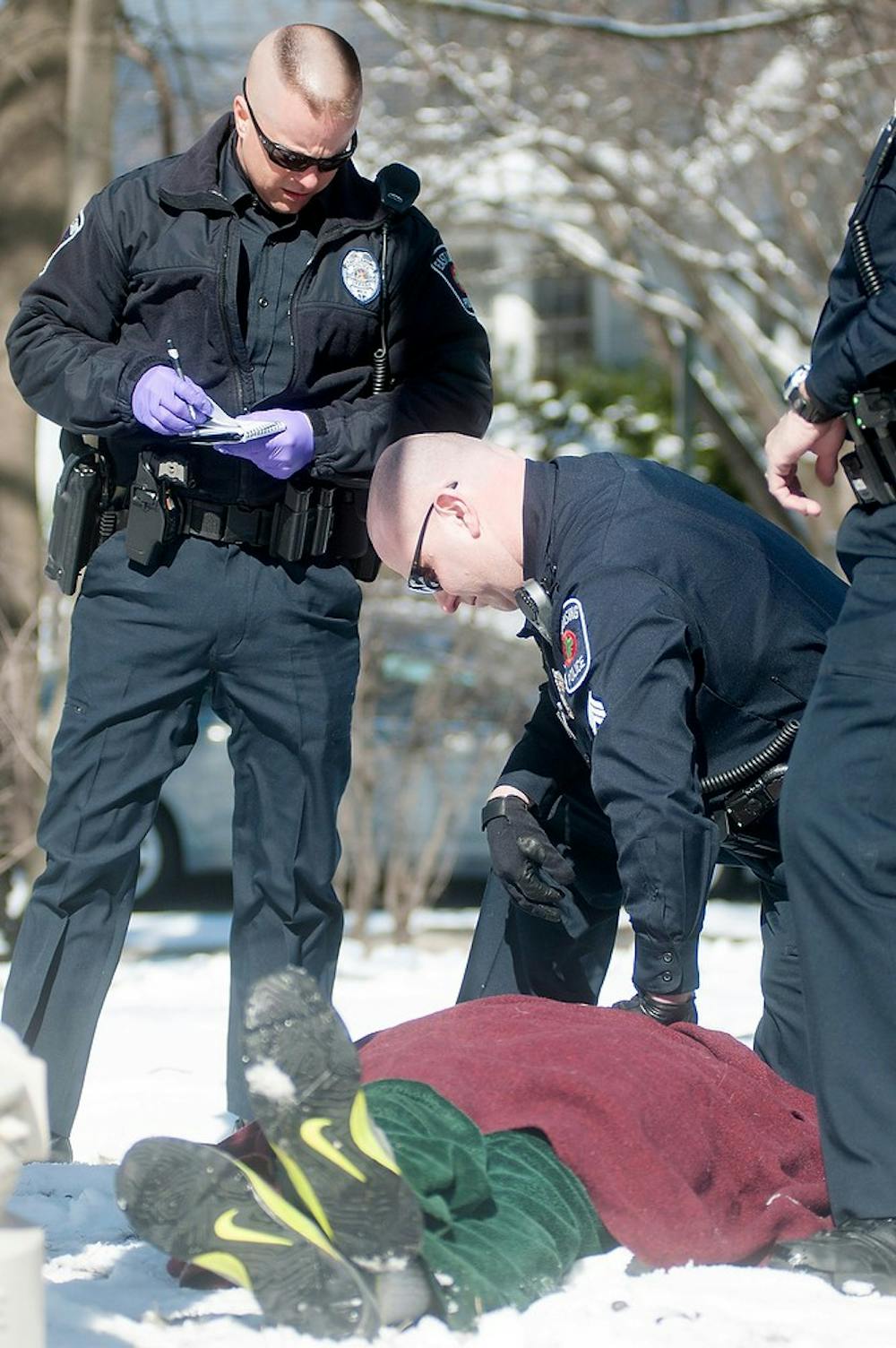 	<p>Officer Erich Vedder, left, and Sgt. Marc Smith tend to an individual after he ran into a lamp post after being questioned about his age and having alcohol with him Sunday on Forest Street. Smith was one of the many <span class="caps">ELPD</span> officers patrolling during St. Patrick&#8217;s Day. Julia Nagy/The State News</p>