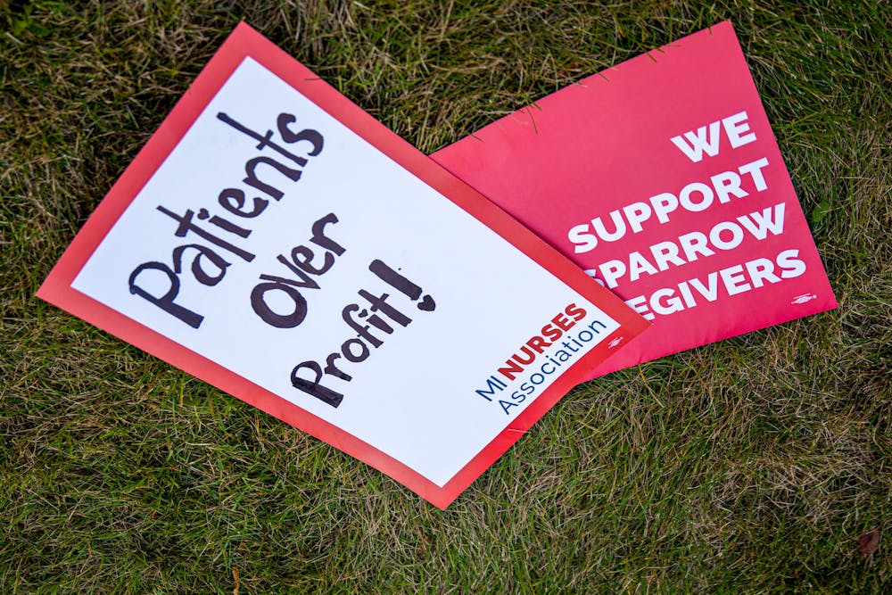 <p>Sparrow nurses along with supporters of them picket along Michigan Avenue in Lansing on Nov. 3, 2021. Shown are two signs lying on the ground during the event.</p>