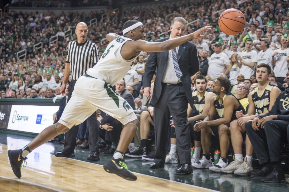 Sophomore guard Cassius Winston (5) reaches for the ball as it edges out of bounds during the first half of the men's basketball game against Purdue on Feb. 10, 2018 at Breslin Center. The Spartans trailed the Boilermakers at the half, 36-31. (Nic Antaya | The State News)