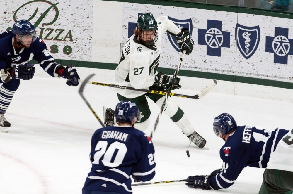 Sophomore forward Mason Appleton (27) splits defenders during an exhibition game against the University of Toronto on Oct. 2, 2016 at Munn Ice Arena. The Spartans defeated the Blues 2-1 in an overtime shootout after ending regulation in a 2-2 tie. 