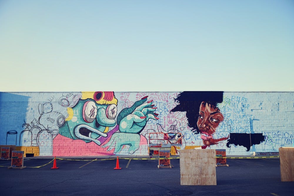 <p>Partially completed mural in Lansing with the Below the Stacks mural art festival. COURTESY OF ALEXIS ROSADO</p>