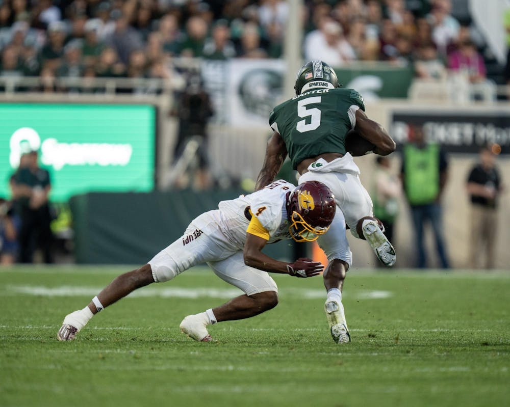 <p>Michigan State Redshirt Sophomore Running Back Nate Carter tackled during a run by Central Michigan Junior Defensive Back Donte Kent during MSU's home opener. Michigan State beat Central Michigan 31-7 at Spartan Stadium.</p>