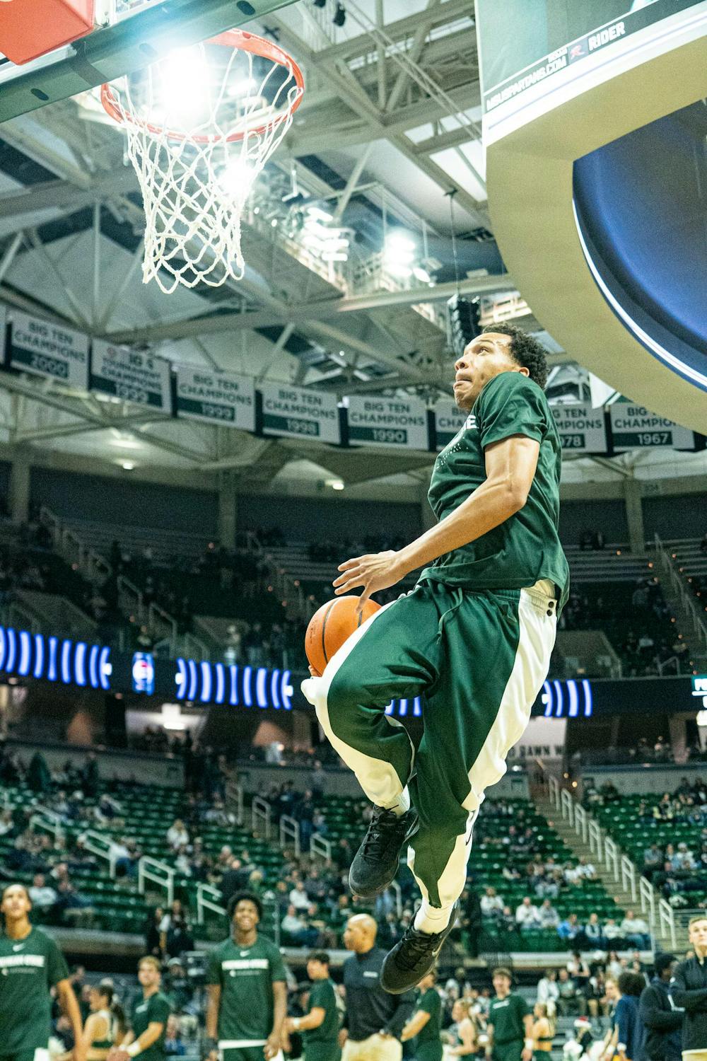 <p>MSU sophomore guard, Divine Ugochukwu (99) jumps toward the net for a slam dunk while warming up for the MSU versus Toledo men's basketball game at the Breslin Center in East Lansing, Michigan on Tuesday, Dec. 16, 2025.</p>