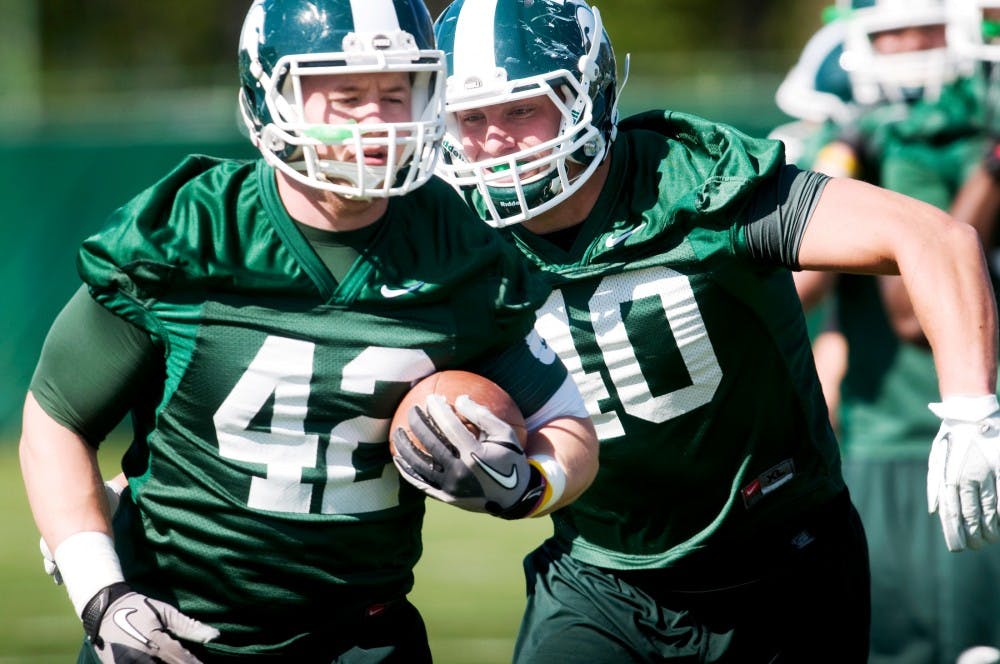 Junior linebacker Max Bullough aims to grab sophomore linebacker Ty Hamilton during practice Tuesday afternoon at the practice fields outside of the Duffy Daughtery Building. Samantha Radecki/The State News