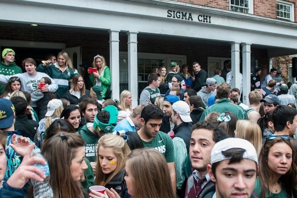<p>Party-goers hangout on Sigma Chi’s lawn on Nov. 2, 2013. Fraternities all over campus hosted large parties before the game.</p>