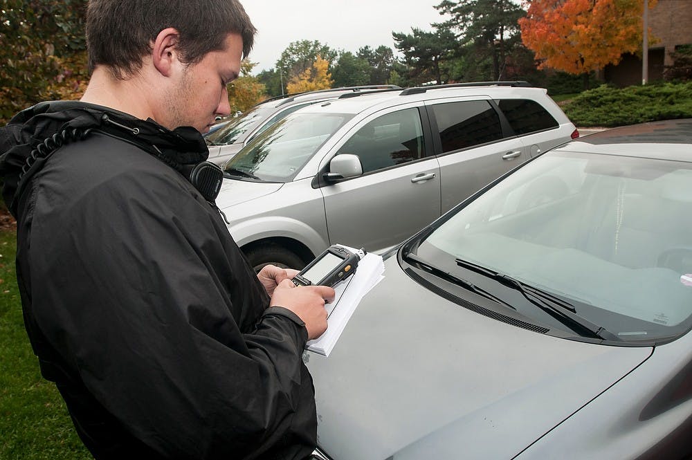 <p>Criminal justice senior Joseph Sears files a parking ticket for a vehicle on Oct. 17. 2014, at the MSU Police Department parking lot. Raymond Williams/The State News</p>