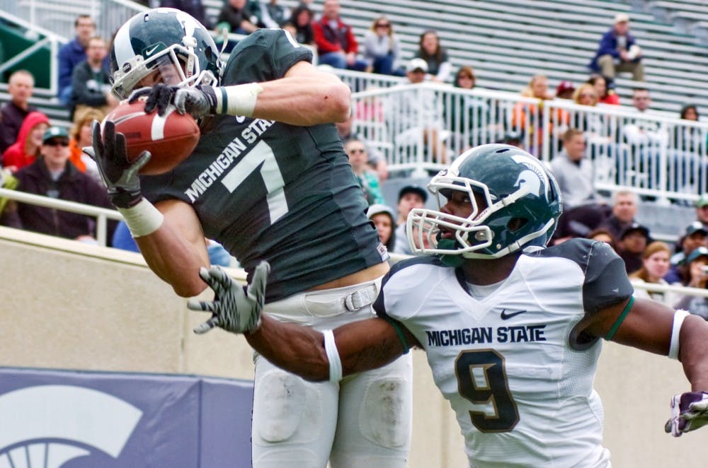 	<p>Senior wide receiver Keith Nichol, left, hauls in a pass over the shoulder of sophomore safety Isaiah Lewis Saturday at Spartan Stadium. The Green team defeated the White team 24-10 in the Spring Game.</p>