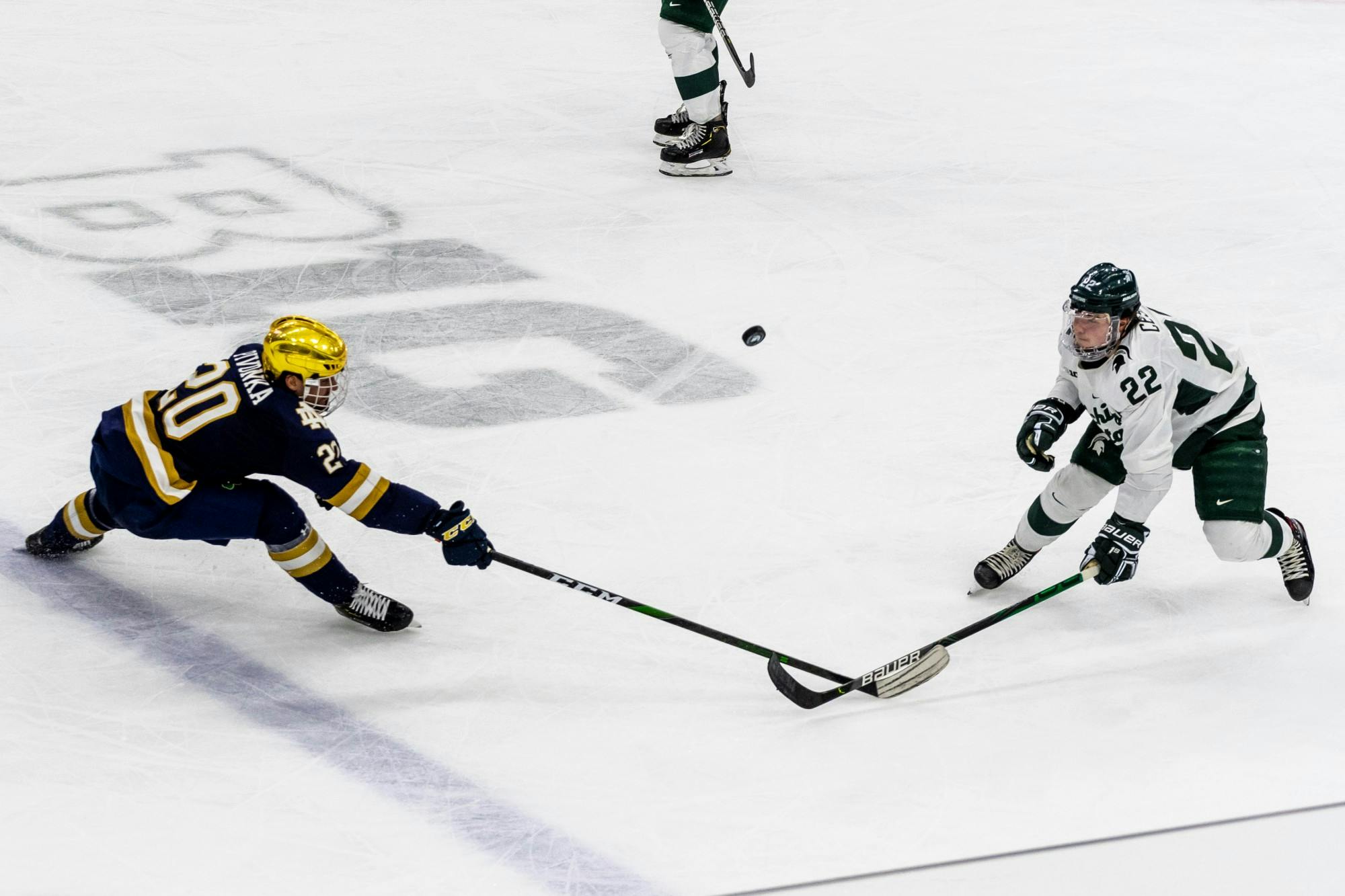 <p>Then-sophomore defender Dennis Cesana (right) and Notre Dame center Jake Pivonka both attempt to bring down the puck. The Spartans tied with the Fighting Irish, 1-1, at Munn Ice Arena on Nov. 22, 2019. </p>