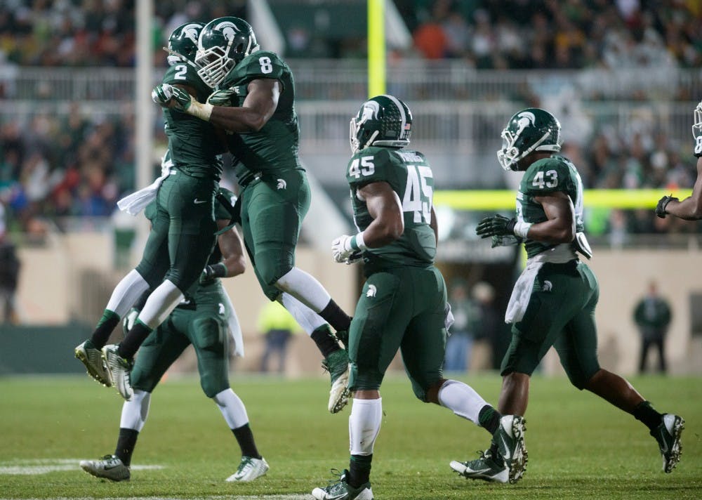 <p>Sophomore cornerback Darian Hicks, 2, celebrates with defensive lineman Lawrence Thomas after Thomas' sack during the game against Nebraska on Oct. 4, 2014, at Spartan Stadium. The Spartans defeated the Cornhuskers, 27-22. Julia Nagy/The State News</p>