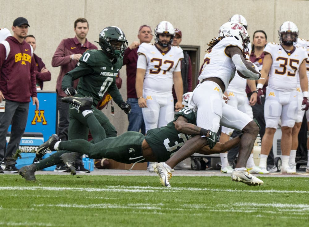 <p>Redshirt junior cornerback Justin White, 30, attempts to tackle Jacob Knuth, 6, during Michigan State’s match against Minnesota on Saturday, Sept. 24, 2022. The Gophers ultimately beat the Spartans, 34-7.</p>