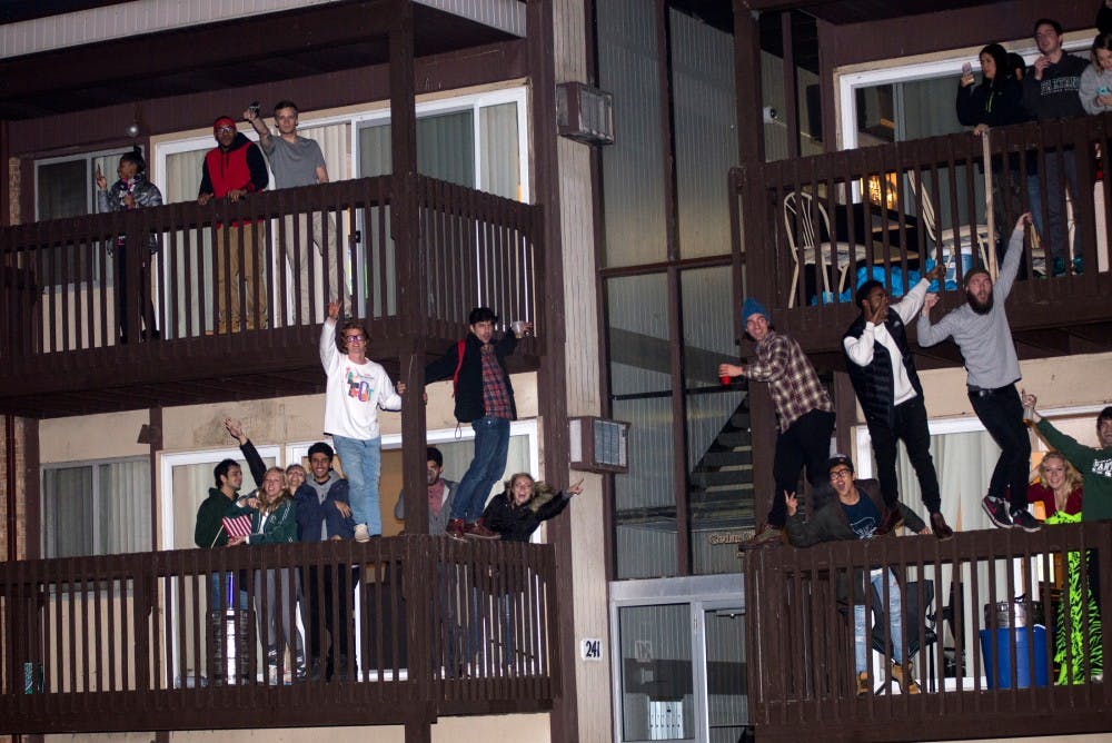 Students cheer from a balcony on Dec. 5, 2015 in Cedar Village. Hundreds of students gathered in Cedar Village to celebrate MSU's victory over Iowa in the Big Ten championship, resulting in police action. 