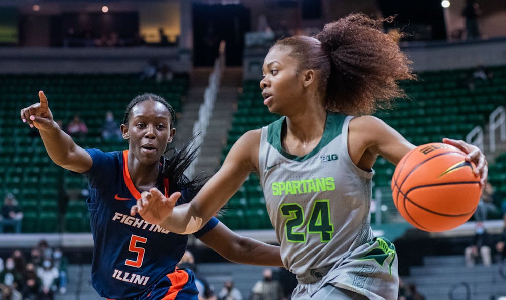 <p>Senior guard Nia Clouden (24) dodges an Illinois guard during the first quarter of the game. The Spartans beat the Fighting Illini, 75-60, in their Big Ten opener on Dec. 9, 2021. </p>