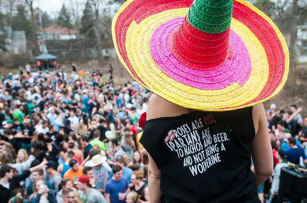 <p>Hospitality business junior Brooke Reinis stands on the roof and looks at the party April 12, 2014, at Nachofest at a house on Stoddard Ave. Nachofest is an annual party where tortilla chips and nacho cheese are provided. Erin Hampton/The State News</p>