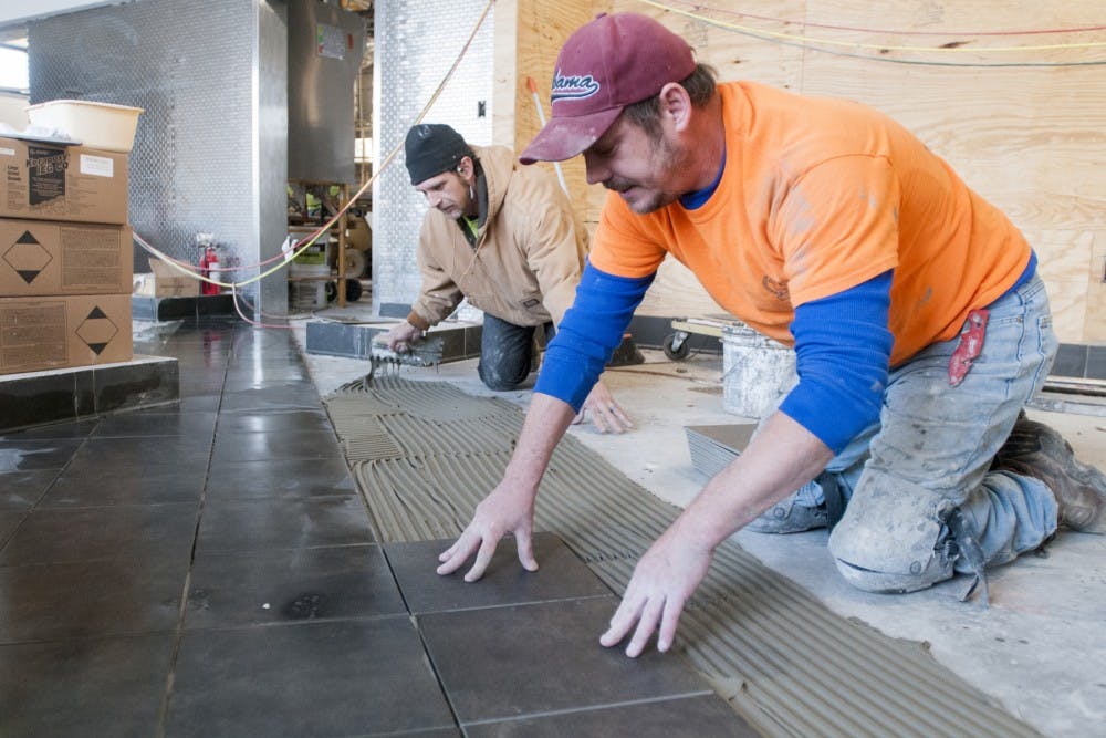 From left, Atlanta Georgia residents Derrick Johnson and Shane Roberts install tiles on Feb. 6, 2017 at the new Chick fil-A in Okemos. The construction is said to be completed by Mar. 30, 2017. 