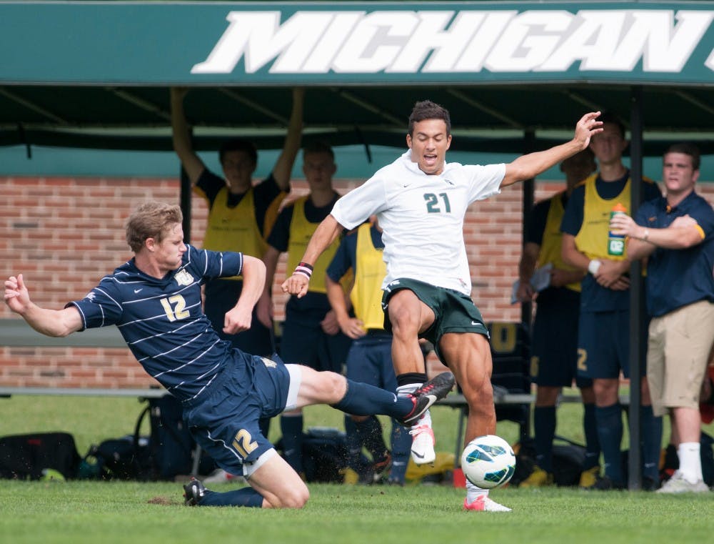 Marquette's midfielder Eric Pothast tackles senior forward Domenic Baroneon Sunday, Sept. 16, 2012 at DeMartin Stadium at Old College Field. Marquette defeated MSU during overtime, 2-1. Justin Wan/The State News