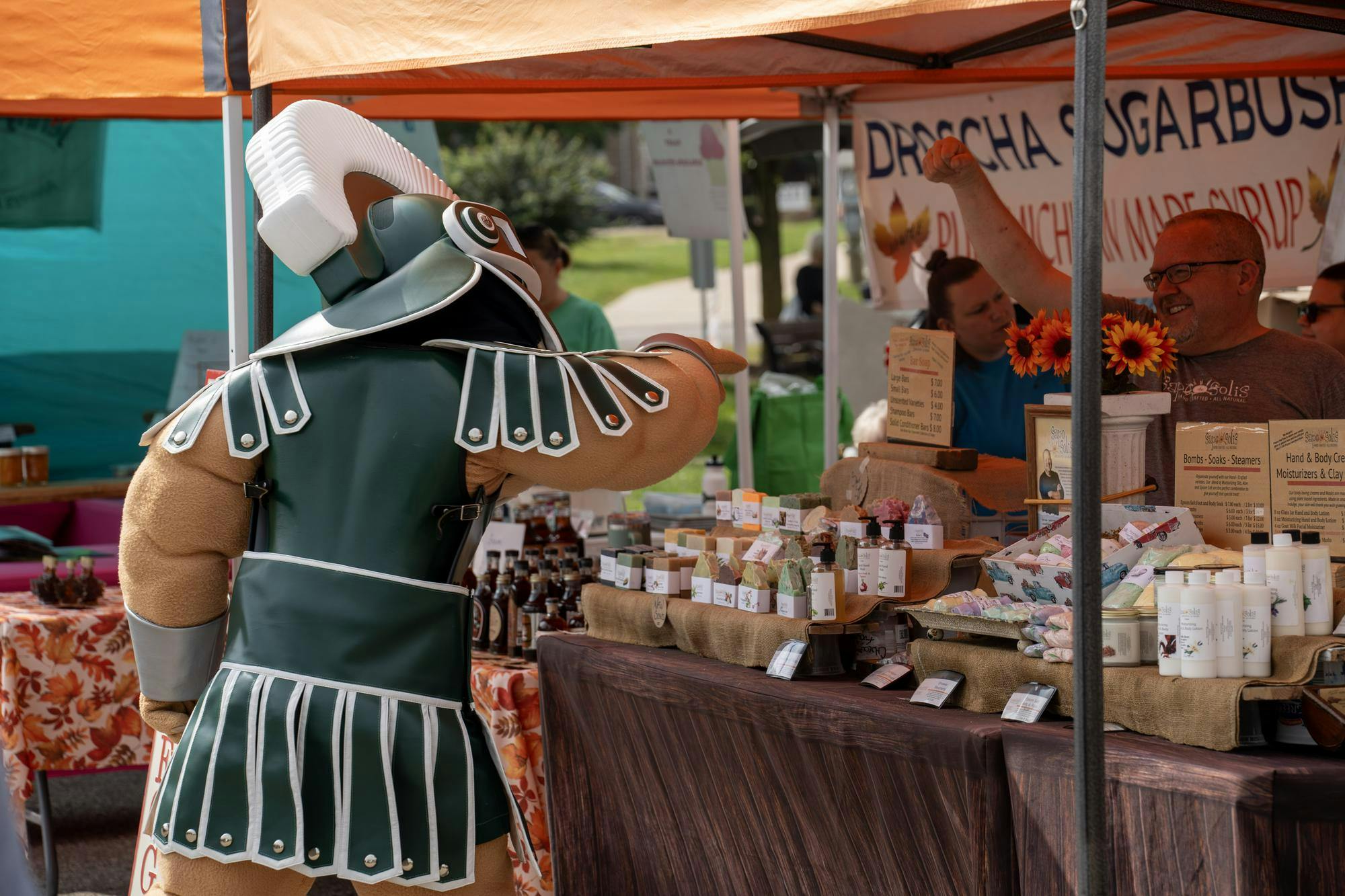 Michigan State mascot Sparty interacts with farmers at the East Lansing Farmers market for Spartan Appreciation Day on September 17, 2023.