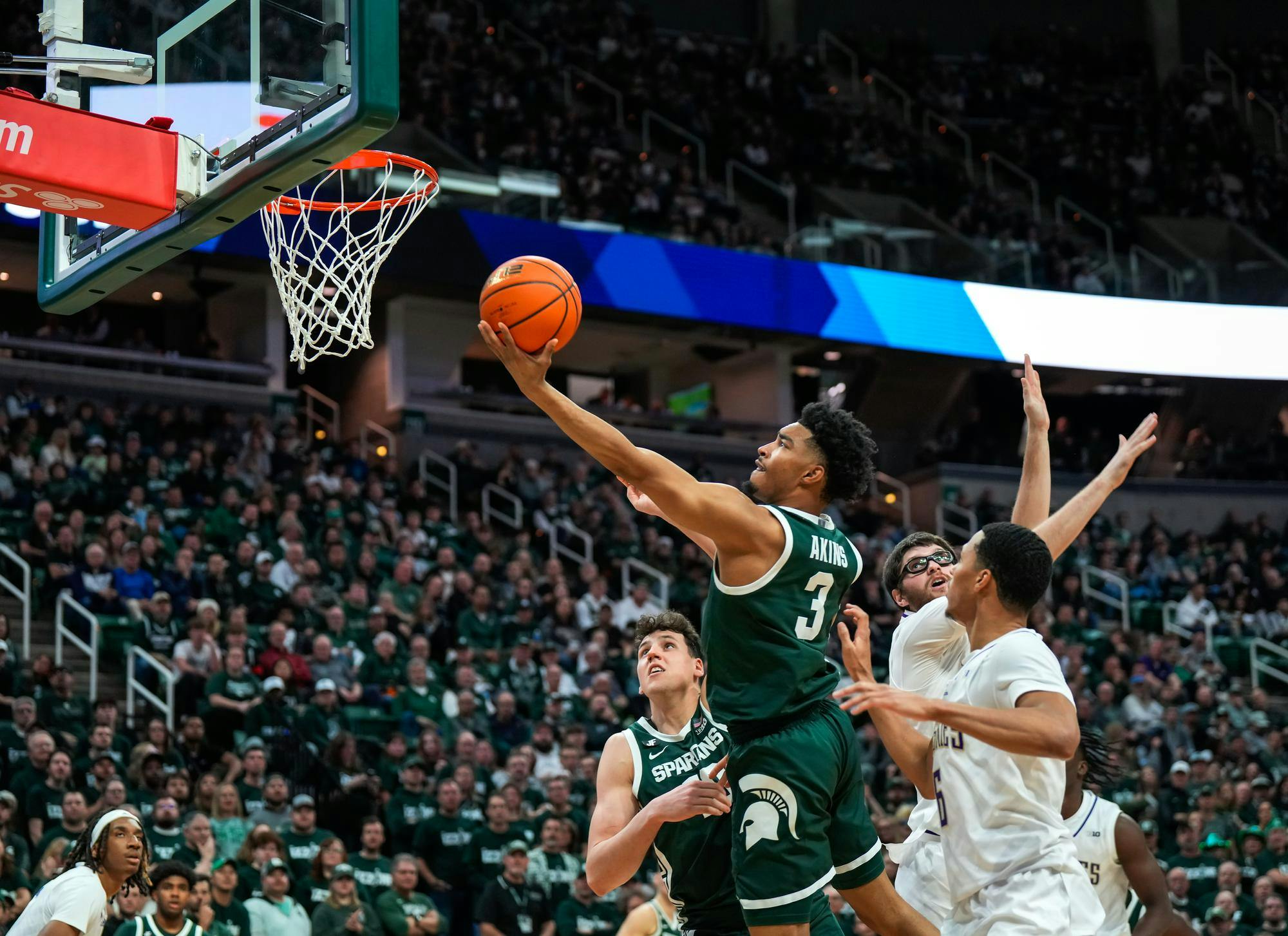 Jaden Akins (3) reaches the basket to score another bucket against Washington on Jan. 9, 2025. 