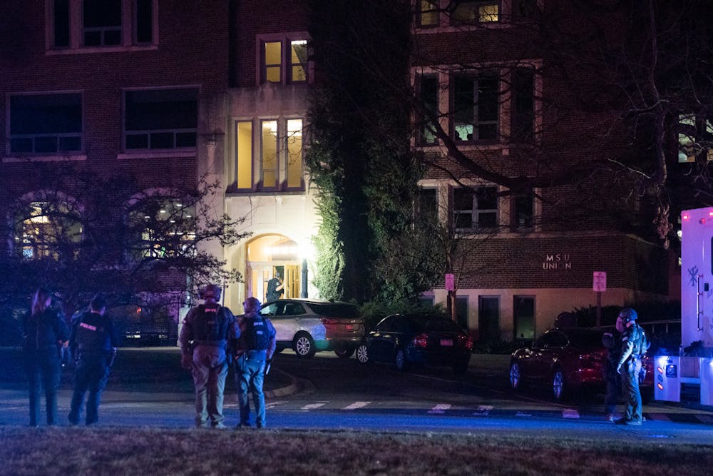 Police officers make their way inside MSU Union as other officers watch on outside as during the response of a shooting on Michigan State’s campus on the night Feb. 13, 2023. 