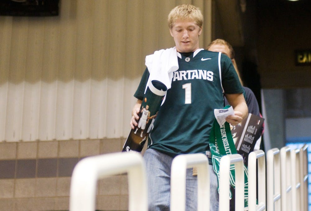 No-preference freshman Jordan Van Dyke walks down to his seat Tuesday evening at the Breslin Center. The Student Alumni Foundation invited Izzone members to Breslin Center to meet players and coaches after the Izzone campout was rained out earlier this semester. Matt Radick/The State News