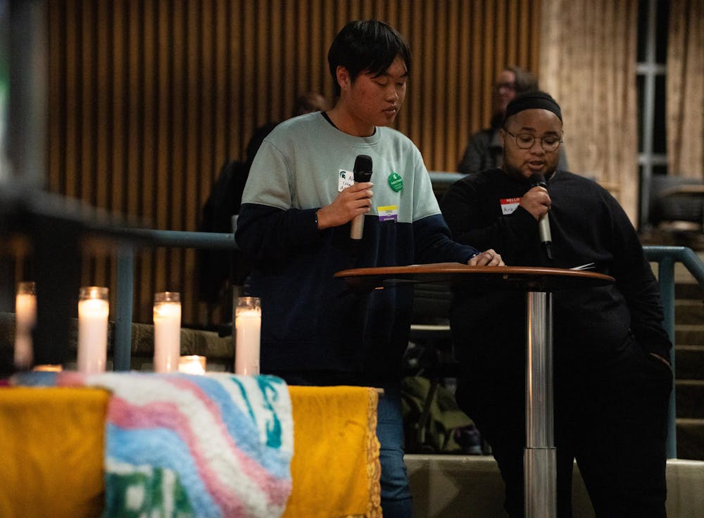 <p>Michigan State humanities sophomore Alex Guo, left, and political science freshman Ares Orion, right, read the names of victims of anti-transgender violence during the university's Transgender Day of Remembrance event at Erickson Hall on Nov. 20, 2024.</p>