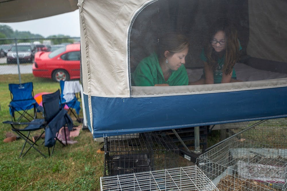 	<p>Williamston, Mich., resident Sara Parsons stays inside the trailer with her daughter Hannah Parsons, 9, as the rain continued, July 31, 2013, at 159th annual Ingham County Fair in Mason, Mich. Sara Parsons said her family has been out camping at the fair since Sunday, and preferred the rainy days to sunny days at the camp. The six-day event features various livestock and sports shows, as well as amusement facilities. Justin Wan/The State News</p>
