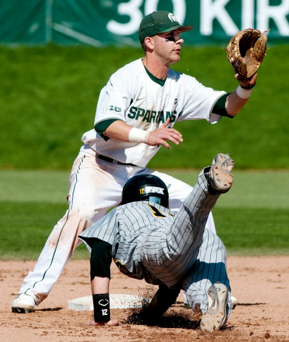 Junior second baseman Ryan Jones waits to catch the ball while Iowa's infielder Jake Mangler dives to secure his position in the game on May 11, 2012 at McLane Baseball Stadium at Old College Field. Justin Wan/The State News