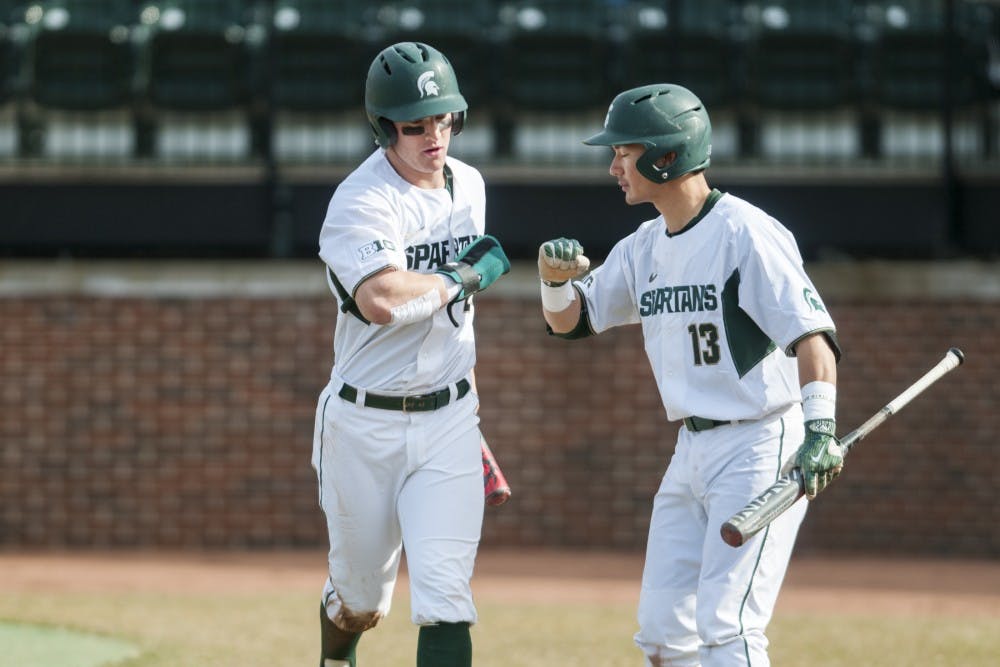 Sophomore infielder Marty Bechina (2) and sophomore infielder Royce Ando (13) pound it during the game against Central Michigan on March 21, 2017 at McLane Stadium at Kobs Field. The Spartans defeated the Chippewas, 11-2.