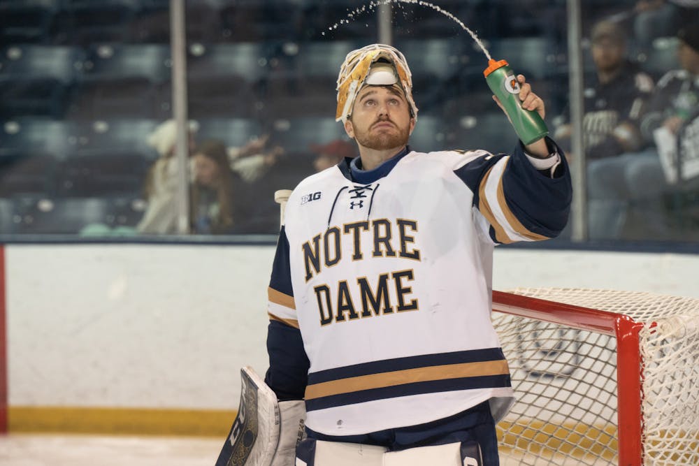 Notre Dame goalie Ryan Bischel squirts an arc of water out of his bottle while performing his pregame rituals at Compton Family Ice Arena in Notre Dame, IN on Friday, March 3, 2023. Bischel posted a shutout with 36 saves during the 1-0 victory against MSU.