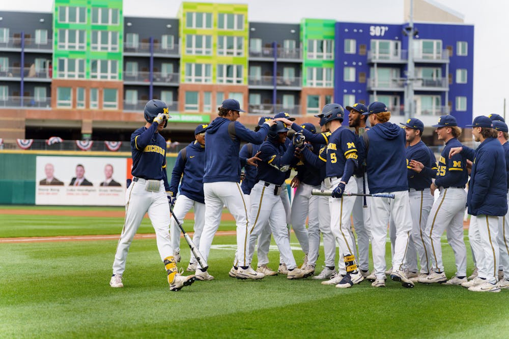 <p>Michigan celebrating with Michigan junior right fielder Clark Elliott (15) after he hits a home run. Michigan State lost 18-6 to Michigan on April 15, 2022, at the Lugnut Stadium.</p>