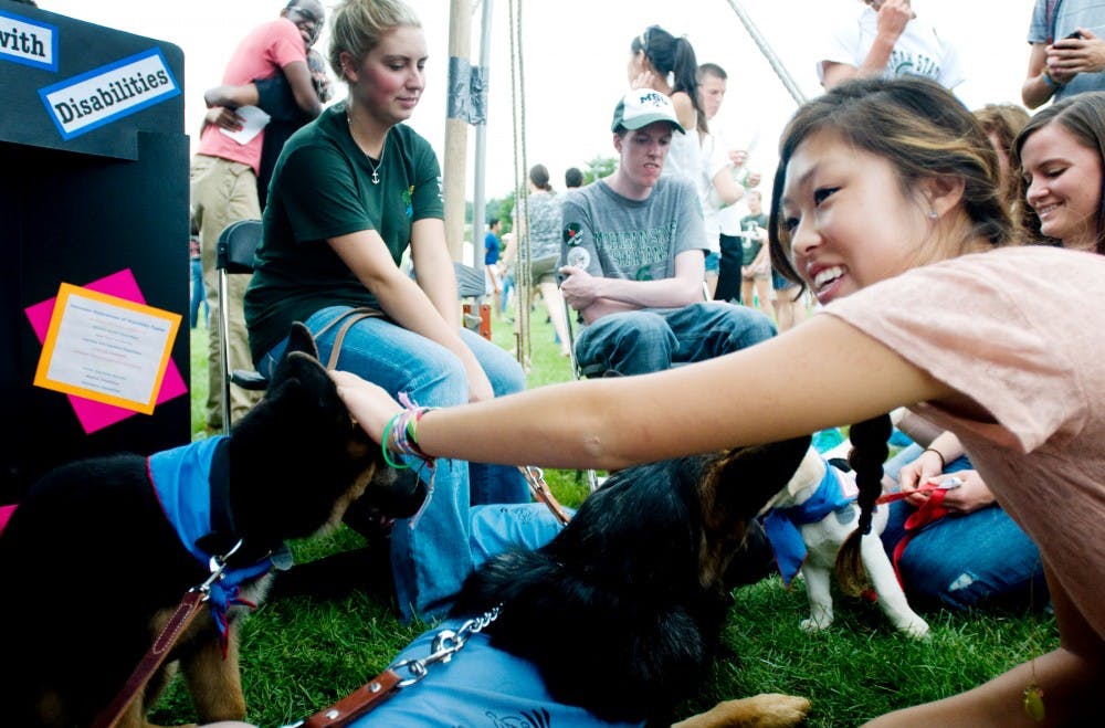 	<p>The Council of Students with Disabilities introduces leader dogs to <span class="caps">MSU</span> student life on Tuesday during Sparticipation. Supply chain management sophomore Susan Jeong stops by to say hello. Mo Hnatiuk/The State News</p>