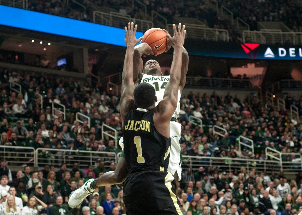 <p>Junior guard Eron Harris throws the ball over Arkansas-Pine Bluff guard Charles Jackson during the first half of the game against Arkansas-Pine Bluff on Nov. 20, 2015 at Breslin Center. The Spartans defeated the Golden Lions, 92-46.</p>