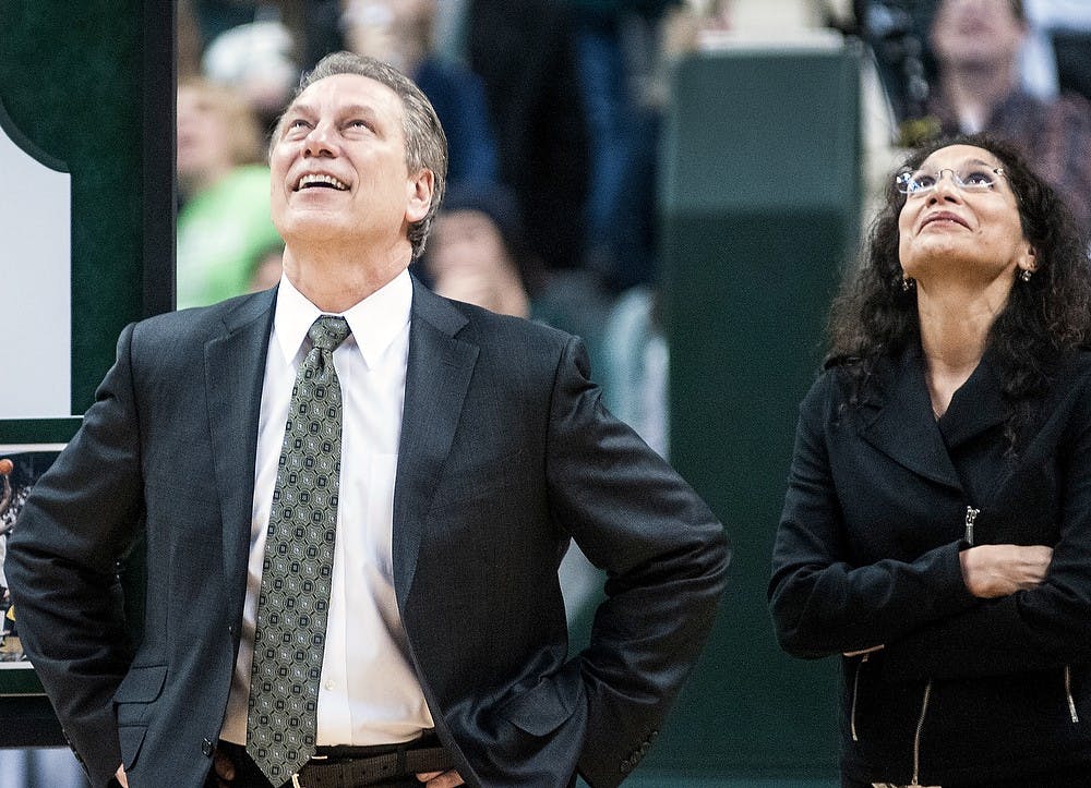 Head coach Tom Izzo and with his wife Lupe Izzo smile at the video about Senior center Derrick Nix's MSU career being played on the screen above the court. Nix was honored after the game because it was Senior Night. Katie Stiefel/The State News