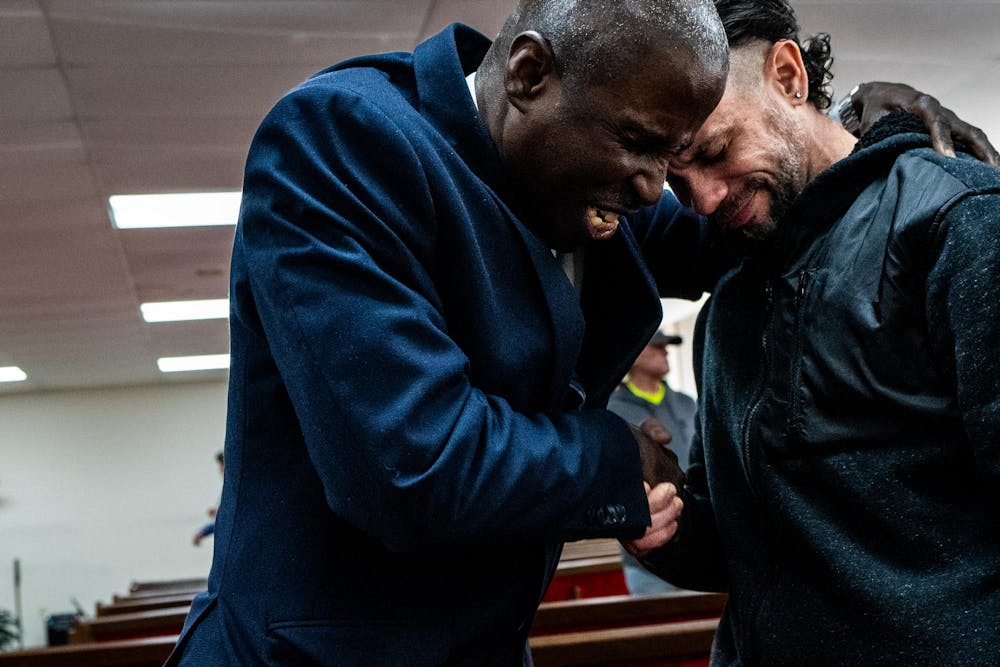 Pastor Michael Venyah prays for Rubin Roig, 42, of Puerto Rico, after a Sunday worship service at Soulwinners Fellowship Church in Lansing, Mich., on Sunday, April 12, 2026.