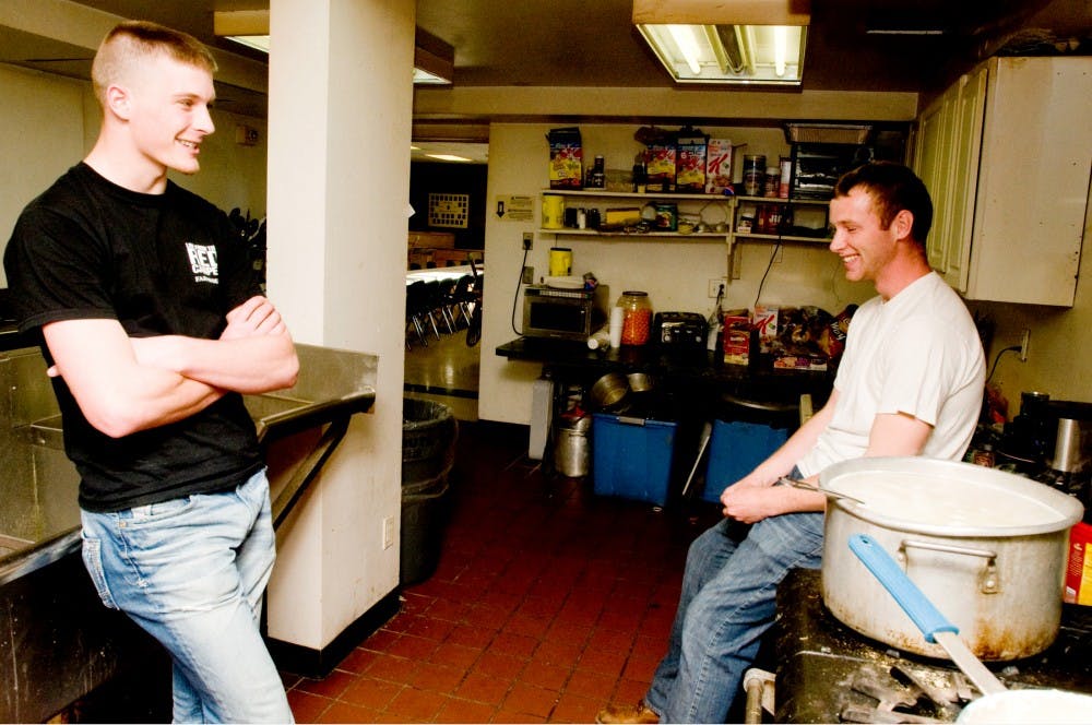 From left, agribusiness management sophomore Rex Thayer and horticulture junior Briar Adams talk to one another while waiting for noodles to finish boiling Tuesday evening at the FarmHouse Fraternity, 151 Bogue St. The East Lansing City Council will consider an application from the house to expand the fraternity to allow for bedroom space for 16 more members as well as put in a small amount of retail space on the first floor. Aaron Snyder/The State News. 
